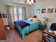 Cozy bedroom with a blue quilt, carpeted floor, and natural light from the window at 175 Monarch Dr, Peachtree City, GA 30269