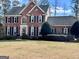 Beautiful brick home with a well-manicured lawn, black shutters, and mature landscaping at 175 Monarch Dr, Peachtree City, GA 30269