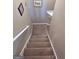 Carpeted staircase with white banister and decorative artwork at 175 Monarch Dr, Peachtree City, GA 30269