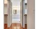 Bathroom view through doors with built-in closet systems, double vanity, white cabinetry, and white tile floors at 40 High St, Sharpsburg, GA 30277