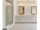 Bathroom featuring glass shower, double vanity with decorative mirror, white cabinetry, and white tile floors at 40 High St, Sharpsburg, GA 30277