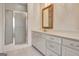 Bathroom featuring glass shower, single vanity with decorative mirror, white cabinetry, and white tile floors at 40 High St, Sharpsburg, GA 30277