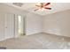 Carpeted bedroom featuring ceiling fan and a doorway view to the hallway and stairs at 40 High St, Sharpsburg, GA 30277