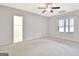 Bright bedroom featuring neutral carpet, a window, a ceiling fan, and an ensuite bathroom at 40 High St, Sharpsburg, GA 30277