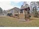 Back of house with screened porch, patio, stairs to yard, landscaping, and lawn at 40 High St, Sharpsburg, GA 30277