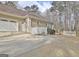 Attached garage with a wide driveway and partial white picket fence at 40 High St, Sharpsburg, GA 30277