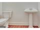 Clean half-bathroom with traditional fixtures, including a pedestal sink and toilet at 40 High St, Sharpsburg, GA 30277