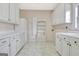 Bright laundry room with white cabinets, shelving, and ample counter space, perfect for organization and chores at 40 High St, Sharpsburg, GA 30277