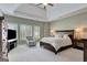 Comfortable primary bedroom with a chair, ceiling fan and bright, shuttered windows at 120 Middleton Dr, Peachtree City, GA 30269