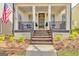 Cozy front porch features dark railing, seating, and elegant potted greenery, framed by classic pillars at 120 Middleton Dr, Peachtree City, GA 30269