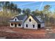 Exterior view of a home under construction with exposed wood and wrap, set in a wooded area at 4585 Parkwood Dr, Social Circle, GA 30025