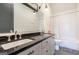 This bathroom features a double vanity, ample lighting, and tiled shower/bath at 135 Kelmscott Ln, Fayetteville, GA 30214