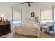 This inviting bedroom features a cozy chair, wood floors, and natural light at 135 Kelmscott Ln, Fayetteville, GA 30214