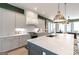 This open kitchen features white marble counters and backsplash, stainless appliances, and pendant lighting at 135 Kelmscott Ln, Fayetteville, GA 30214