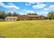 Expansive front yard showcasing a brick home with a covered porch and a detached garage at 229 Callaway Rd, Fayetteville, GA 30215