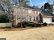 A two-story brick house with a well-kept lawn, mature trees, and an attached two-car garage at 5074 Oak Leaf Ter, Stone Mountain, GA 30087