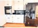 Well-equipped kitchen with white cabinets and modern black appliances for cooking at 5074 Oak Leaf Ter, Stone Mountain, GA 30087