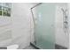 Modern bathroom featuring glass shower door and marble tiled walls at 612 Champions Dr, Mcdonough, GA 30253