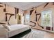 Bright bedroom with abstract wall design, hardwood floors, and plenty of natural light at 612 Champions Dr, Mcdonough, GA 30253