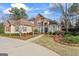 Stunning brick home with a circular driveway and professionally landscaped front yard, creating a grand entrance at 612 Champions Dr, Mcdonough, GA 30253