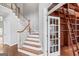 Stylish staircase with wooden banister and white risers, leading to an upper level with a library at 612 Champions Dr, Mcdonough, GA 30253