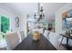 Dining room with table, seating for six, modern lighting, and a view into the kitchen, living room and outside at 3785 Pilgrim Mill Rd, Cumming, GA 30041