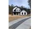 Stunning two-story modern farmhouse featuring white siding, black accents, and well-maintained front yard at 3785 Pilgrim Mill Rd, Cumming, GA 30041