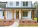 Attractive front porch with wood columns, brick accents, and elegant outdoor lighting fixtures at 3785 Pilgrim Mill Rd, Cumming, GA 30041