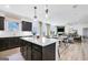 Open kitchen with dark cabinets, quartz countertops, island seating, and seamless access to living areas at 120 Aj Welch Jr Way, Mcdonough, GA 30252