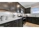 Elegant kitchen featuring sleek dark cabinetry, a subway tile backsplash, and modern appliances at 120 Aj Welch Jr Way, Mcdonough, GA 30252