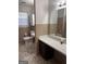A traditionally styled bathroom with a built-in vanity, neutral tile, and separate toilet and tub areas at 103 Emory Way, Oxford, GA 30054