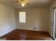 Cozy room with wood-paneled walls, hardwood floors, ceiling fan, and natural light from the window at 103 Emory Way, Oxford, GA 30054