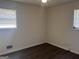 Bedroom featuring light walls, modern dark wood-look flooring, ceiling fan and two bright windows at 103 Emory Way, Oxford, GA 30054
