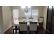 Bright dining room with wood floors, a modern chandelier, and views of the backyard at 7522 Springbox Dr, Fairburn, GA 30213