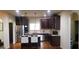 Modern kitchen with dark cabinets, stainless steel appliances and a granite countertop at 7522 Springbox Dr, Fairburn, GA 30213