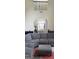 Living room featuring a large gray couch with an ottoman and high ceilings at 7522 Springbox Dr, Fairburn, GA 30213