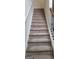 Carpeted staircase with a wrought iron railing, leading to the upper level of the home at 7522 Springbox Dr, Fairburn, GA 30213