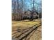 A wide view of a two-story home with black shutters, set back on a spacious lot with mature trees at 245 Ashley Forest Dr, Fayetteville, GA 30214