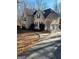 A two-story home with a winding driveway and attached two-car garage, surrounded by trees and shrubbery at 245 Ashley Forest Dr, Fayetteville, GA 30214