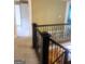 Hallway with wrought iron railing and doorways to multiple carpeted rooms at 245 Ashley Forest Dr, Fayetteville, GA 30214