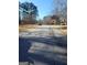Quiet residential street showcasing a well-maintained asphalt road with tree-lined sidewalks, offering a peaceful neighborhood setting at 245 Ashley Forest Dr, Fayetteville, GA 30214
