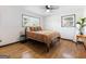 Bright bedroom with hardwood floors, ceiling fan, and natural light from two large windows at 3044 Sunset Ln, East Point, GA 30344