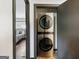 A laundry closet showcasing a stacked washer and dryer unit next to a bedroom at 3044 Sunset Ln, East Point, GA 30344