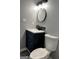 Stylish bathroom featuring a modern vanity with dark blue cabinets, sink, and a toilet at 23 Hampton Locust Grove Rd, Hampton, GA 30228