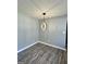 An elegant dining room with a modern light fixture, gray walls, and new wood flooring at 23 Hampton Locust Grove Rd, Hampton, GA 30228