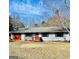 Charming ranch-style home with a red garage door, shutters, and manicured front yard at 23 Hampton Locust Grove Rd, Hampton, GA 30228