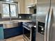 An updated kitchen includes stainless steel appliances, blue lower cabinets, and modern countertops at 23 Hampton Locust Grove Rd, Hampton, GA 30228
