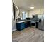 This contemporary kitchen has blue cabinets, white upper cabinets, stainless appliances, and new countertops at 23 Hampton Locust Grove Rd, Hampton, GA 30228