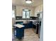 Modern kitchen with white upper cabinets, blue lower cabinets, island, stainless steel appliances, and wood floors at 23 Hampton Locust Grove Rd, Hampton, GA 30228