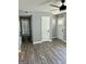 A well-lit living room showcasing modern gray wood flooring, light gray walls, and white doors at 23 Hampton Locust Grove Rd, Hampton, GA 30228